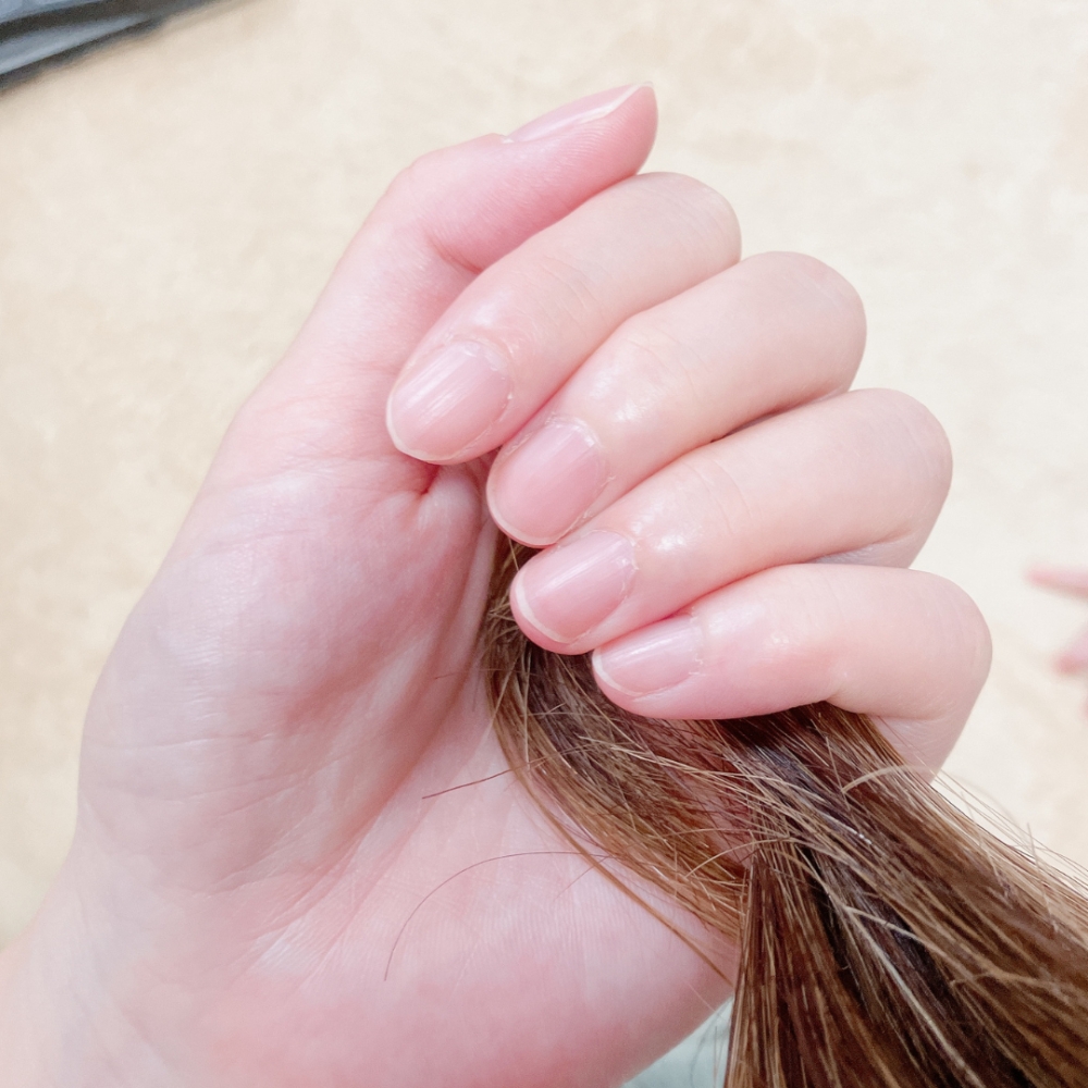 毛先から中心にヘアエッセンスオイルを髪全体につけていく。